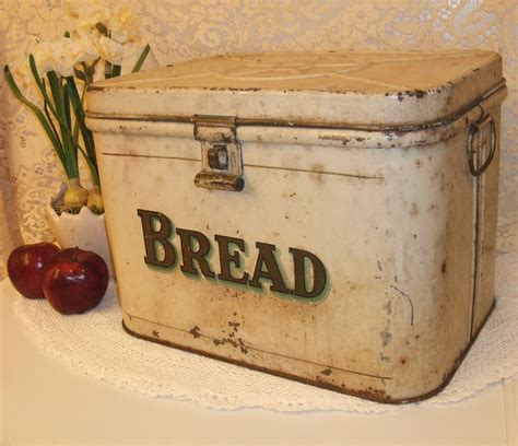 old fashioned metal bread box with bread on the front|old fashioned wooden bread box.